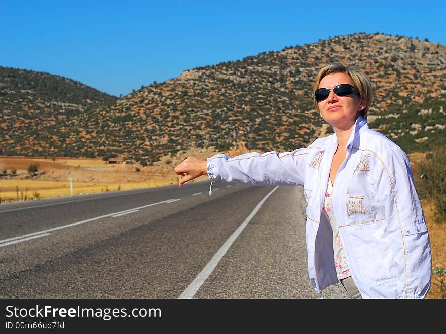 The girl catches machine on road to a background of mountains. The girl catches machine on road to a background of mountains