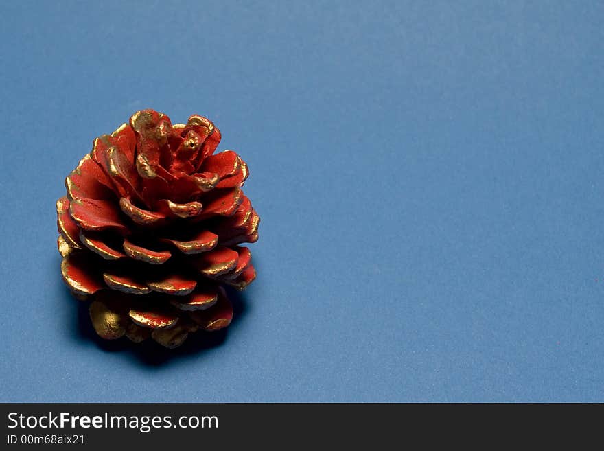 Abstract christmas decoration with Red christmas pine cone isolated on blue background. Abstract christmas decoration with Red christmas pine cone isolated on blue background