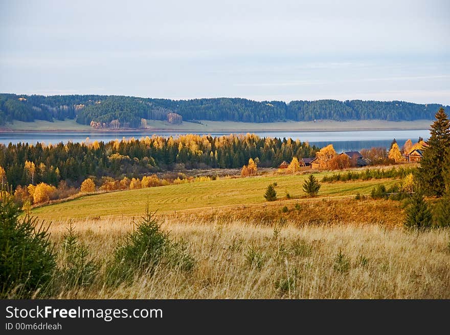 October country landscape with river, forest and meadows.