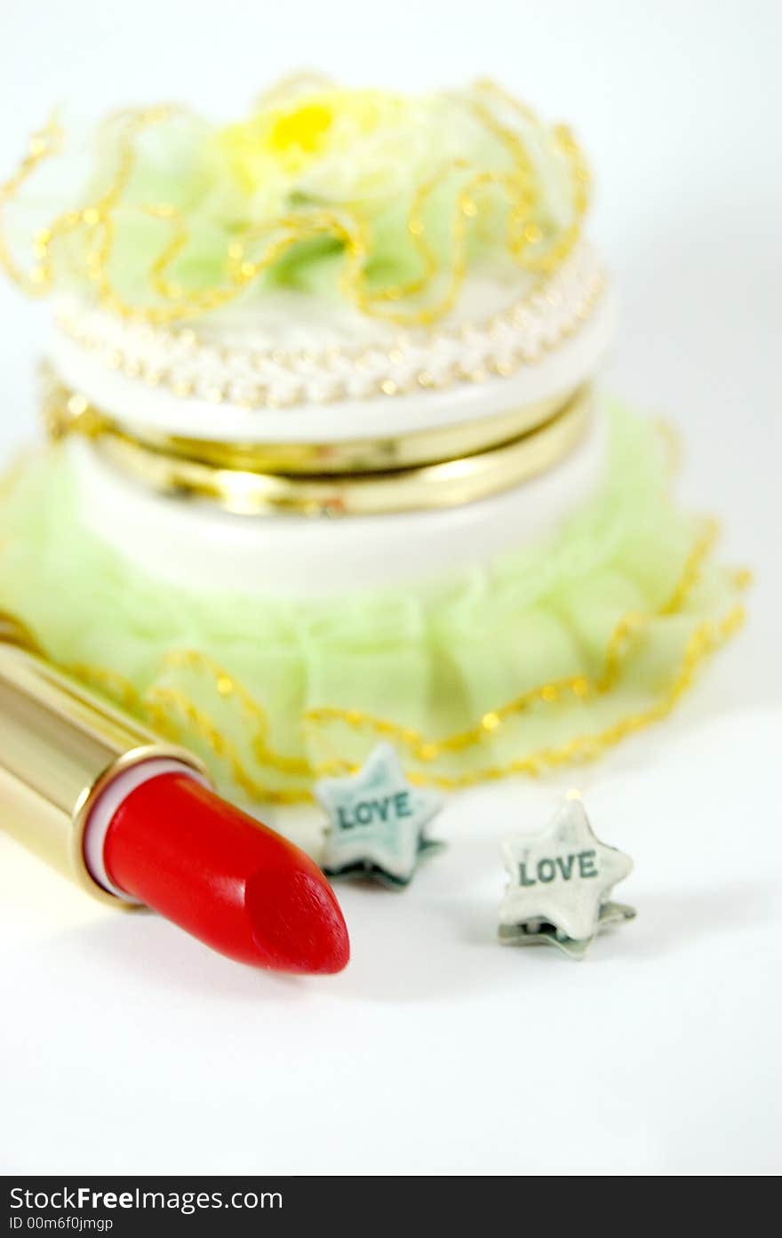 Green decoration box, red lipstick and hair pins with word love written. Green decoration box, red lipstick and hair pins with word love written