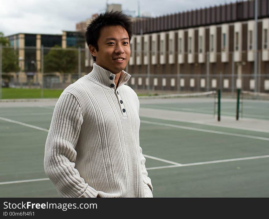 A boy standing in tennis court. A boy standing in tennis court