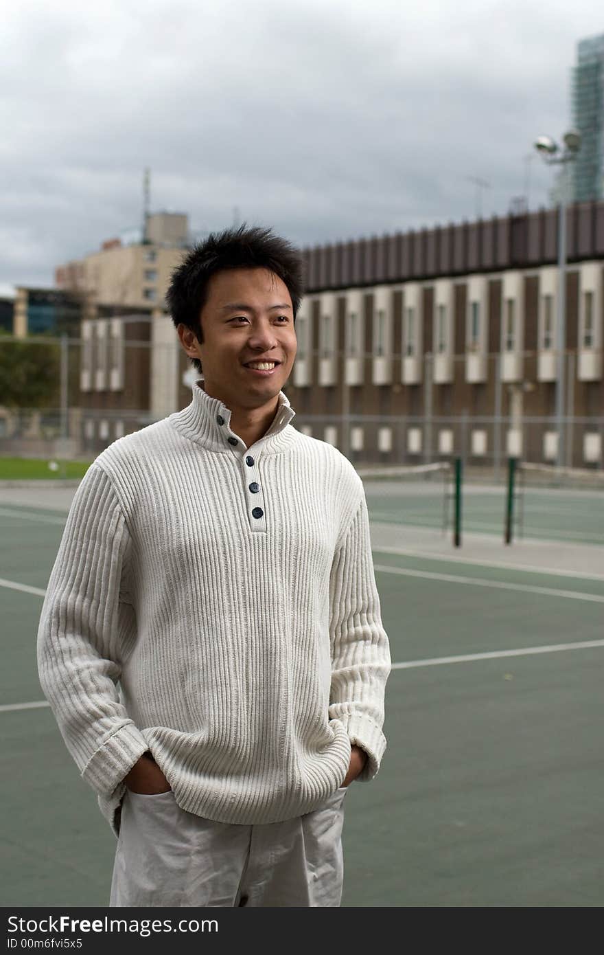 A boy standing in tennis court wearing sports clothing. A boy standing in tennis court wearing sports clothing