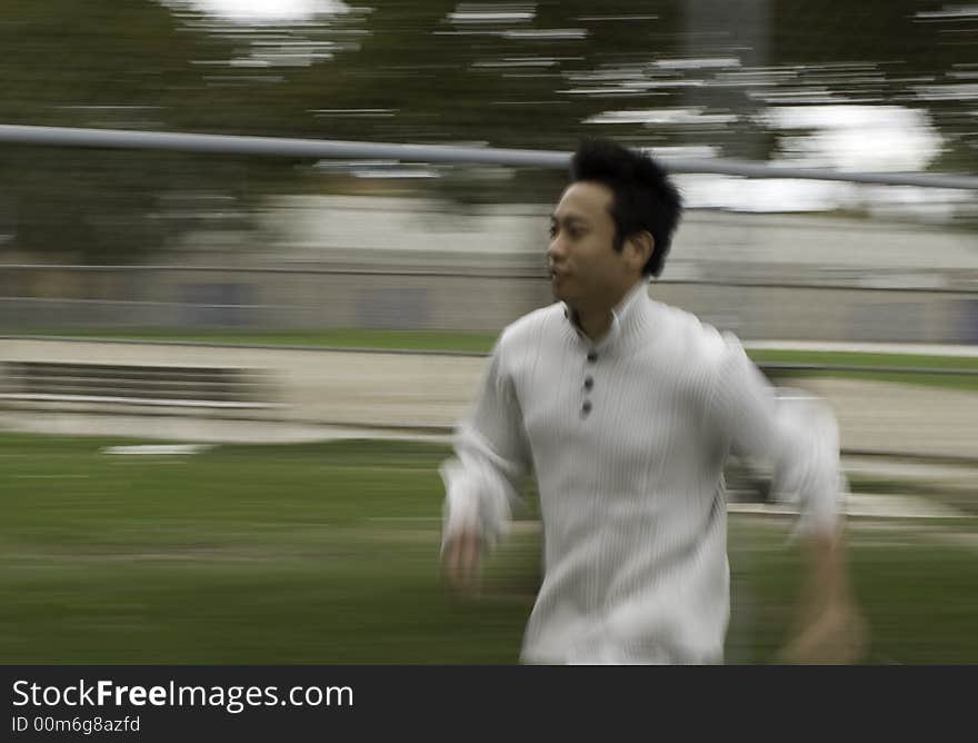 A boy running in tennis court wearing sports clothing. A boy running in tennis court wearing sports clothing