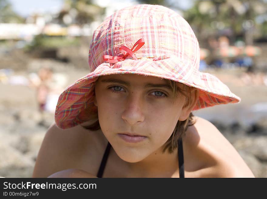 Teenage girl in the hat on the beach