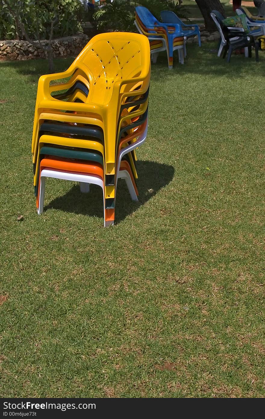 Bright multi-coloured chairs on a lawn near pool. Bright multi-coloured chairs on a lawn near pool