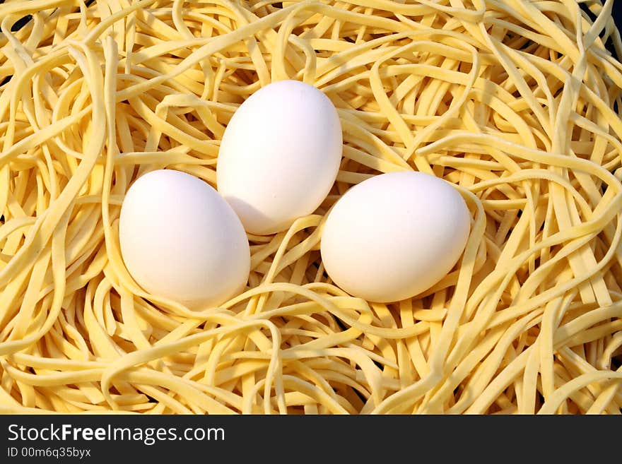 Fresh spaghetti and three white eggs. Fresh spaghetti and three white eggs.