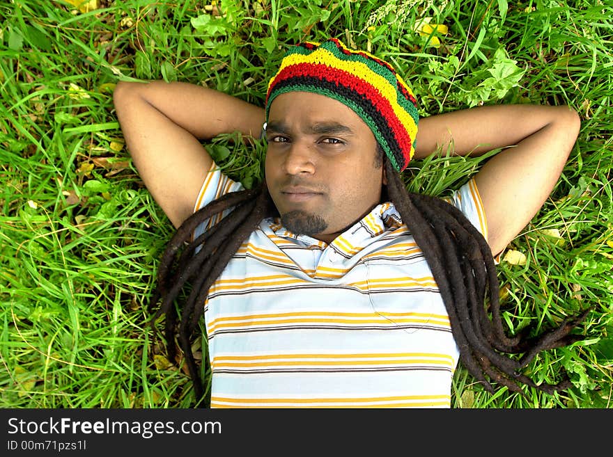 Upset Rastafarian Jamaican laid on grass. Upset Rastafarian Jamaican laid on grass