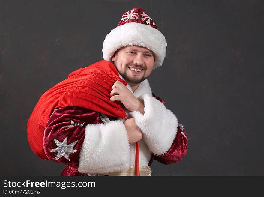 Santa Claus carrying a bag with gifts. Santa Claus carrying a bag with gifts