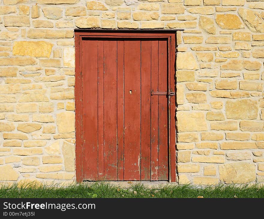 Shuttered red old door and brick wall