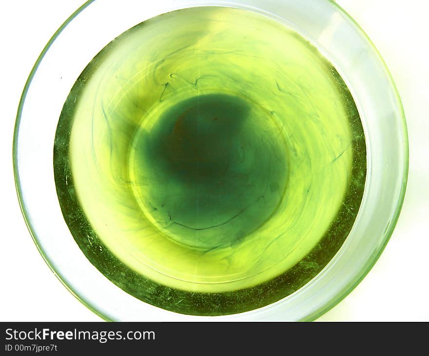 Picturized of top of a bowl full of water with some drops of color. Picturized of top of a bowl full of water with some drops of color