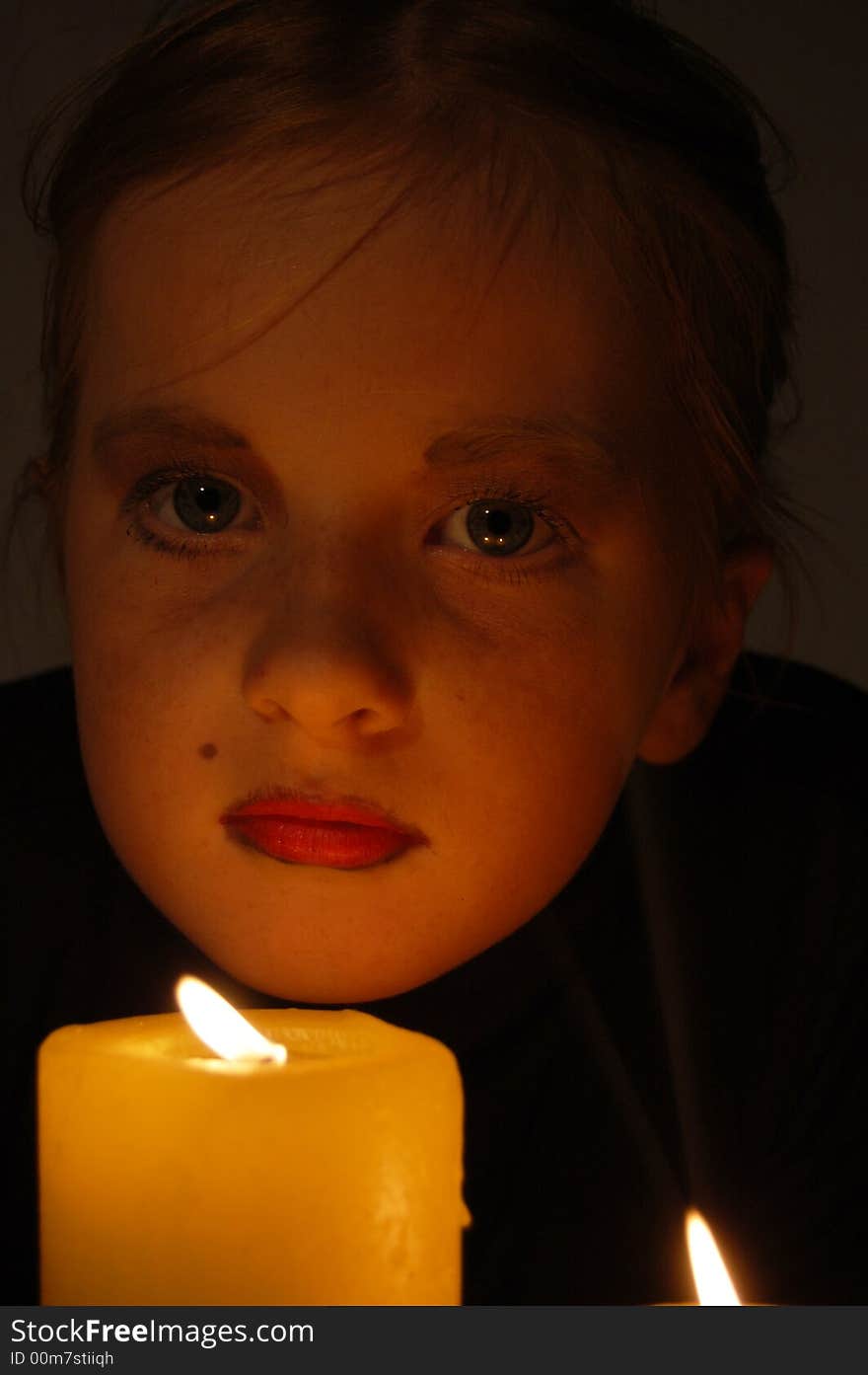 Young girl in candlelight with big eyes. Young girl in candlelight with big eyes