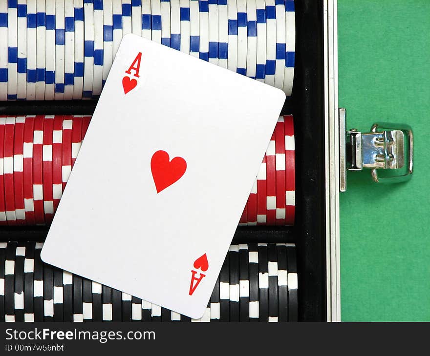 A close up on an ace card over poker chips arranged inside a carrying case. Three rows with white, red and black chips. A close up on an ace card over poker chips arranged inside a carrying case. Three rows with white, red and black chips.