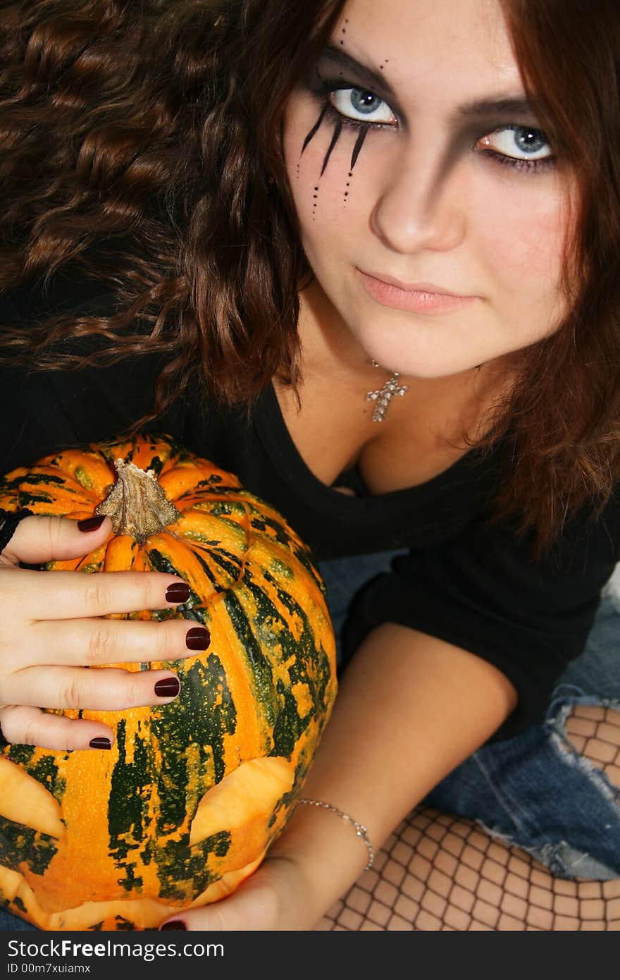 Adorned girl to Halloween c by pumpkin in the hands. Adorned girl to Halloween c by pumpkin in the hands