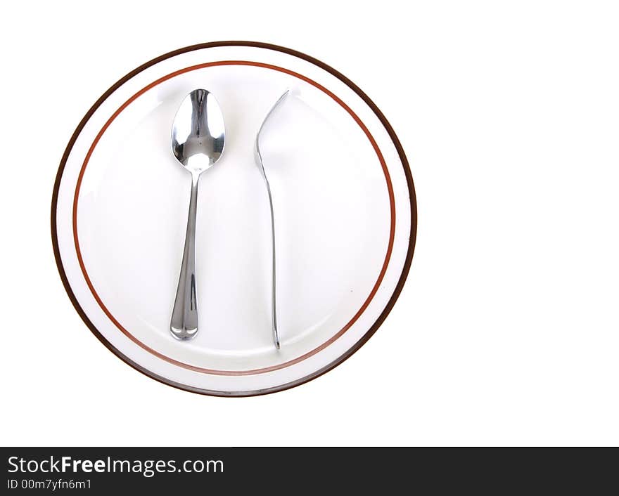 Odd position of fork turn back on spoon placed on a dinner plate. Odd position of fork turn back on spoon placed on a dinner plate