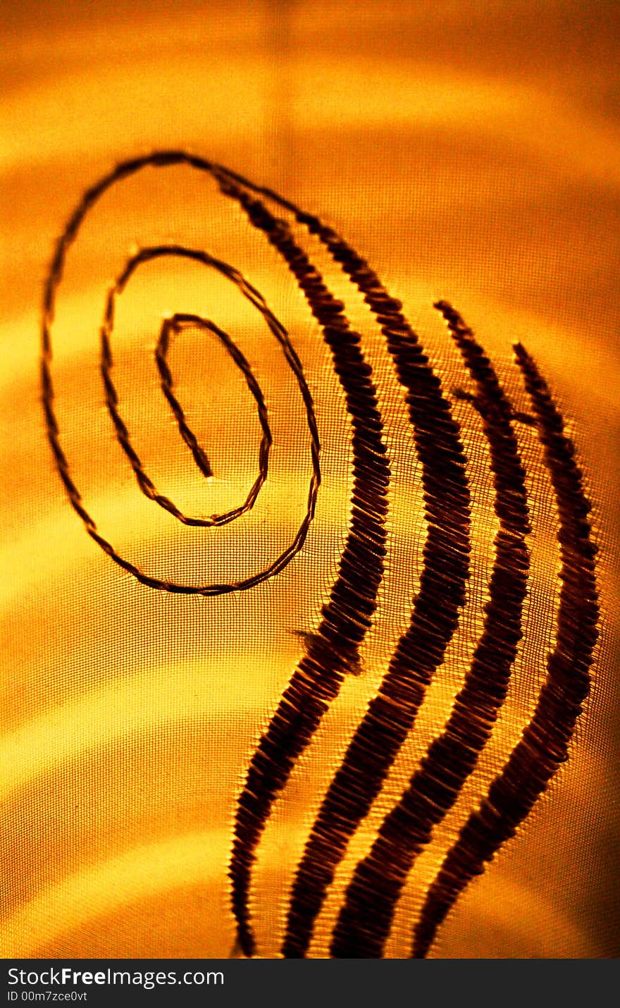 A closeup of a detail on a piece of fabric in front of sun lighting. A closeup of a detail on a piece of fabric in front of sun lighting.