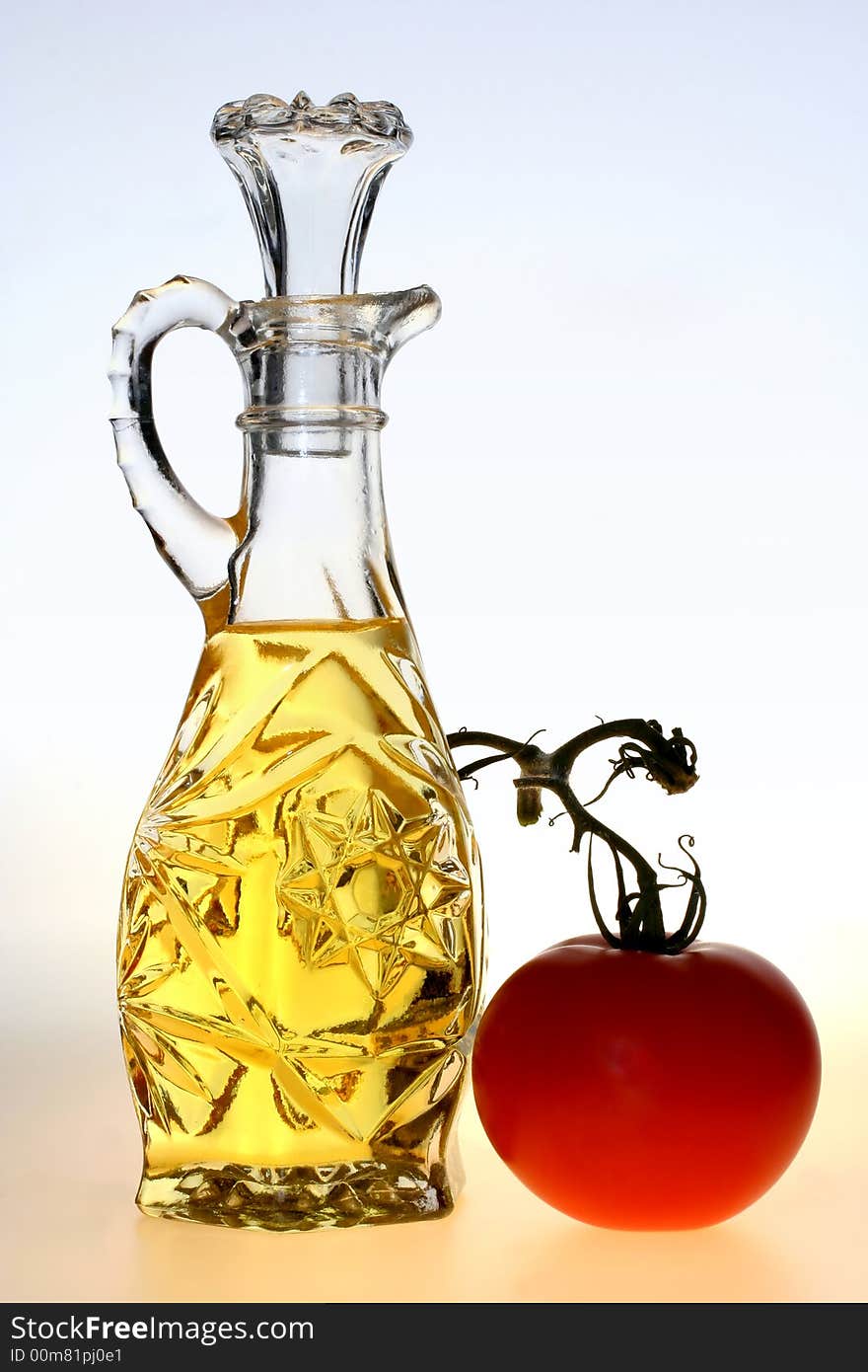 Oil pitcher with a tomato on a blue and yellow background. Oil pitcher with a tomato on a blue and yellow background.