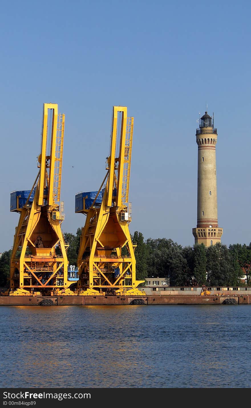 Lighthouse and cranes by the sea. Lighthouse and cranes by the sea