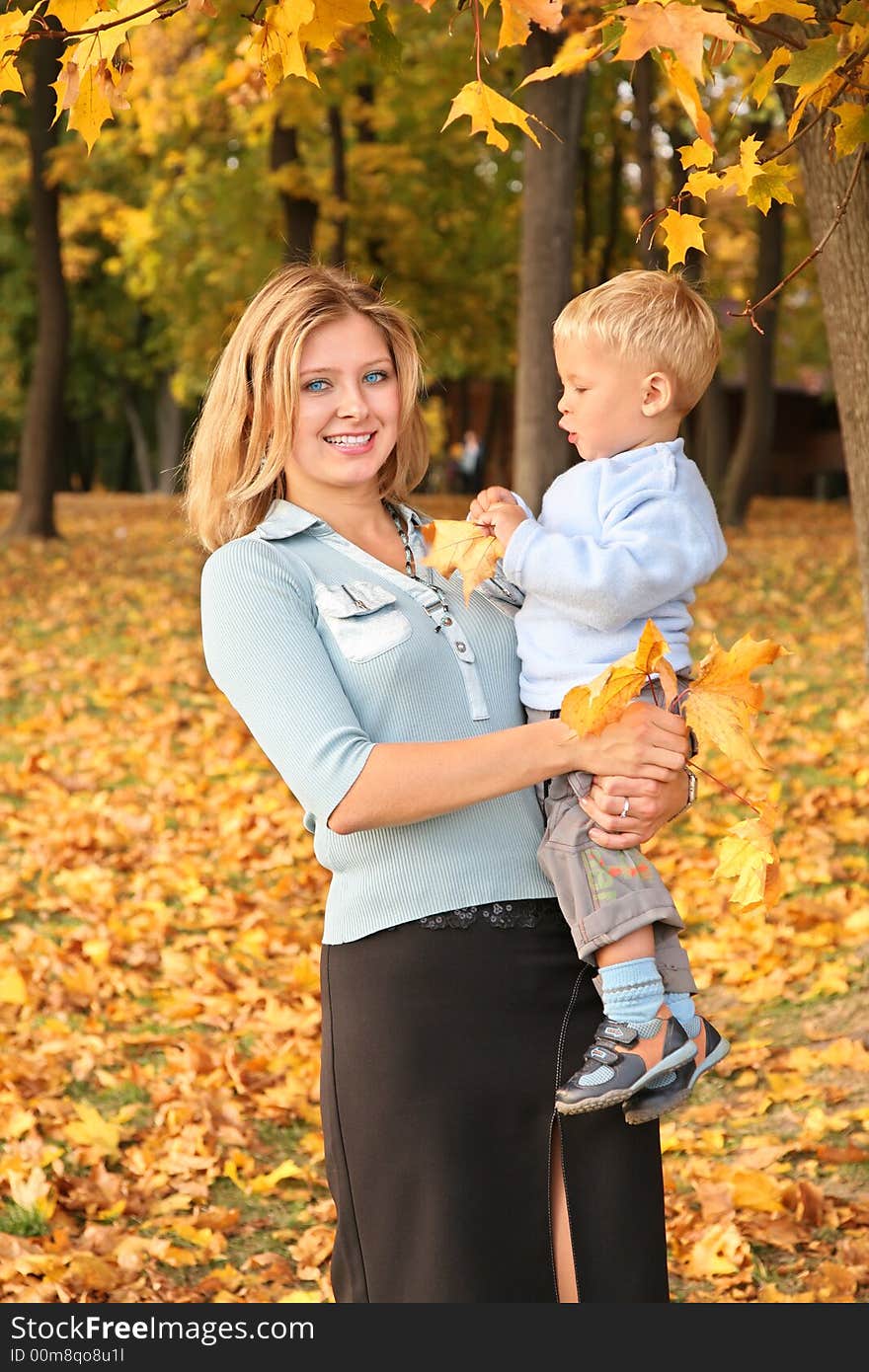 Blue-eyed blond with the son in the park in autumn. Blue-eyed blond with the son in the park in autumn