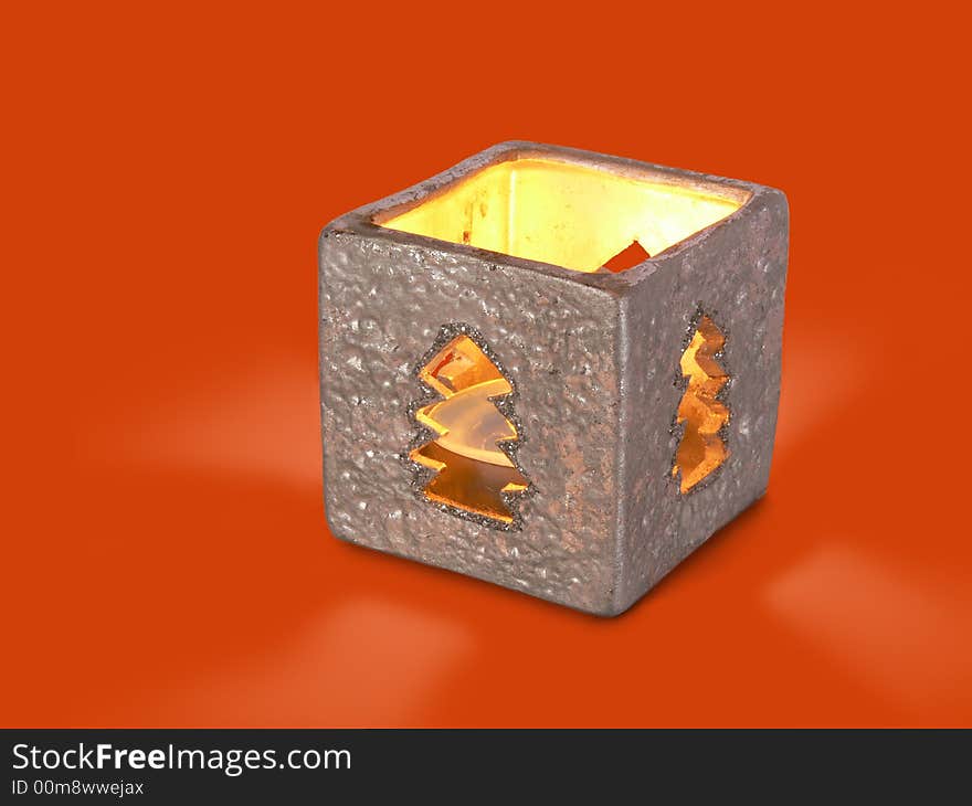 There is xmascandle in silver box-candlestick on red background