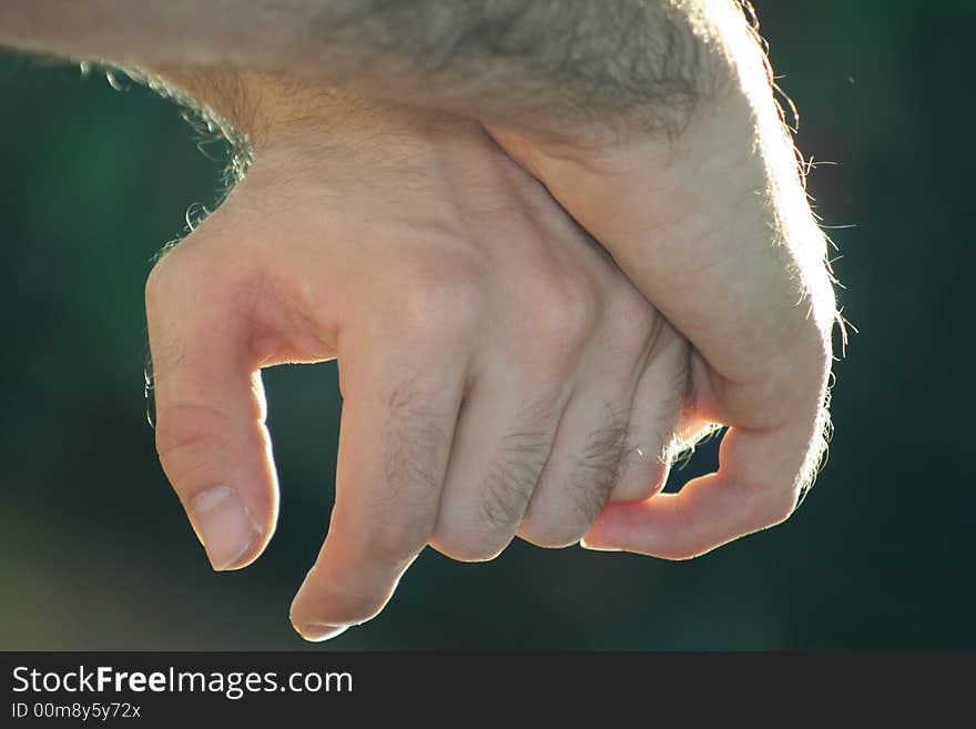 The hands of a guy who rests / Hair / Arms / Intense light from sunlight. The hands of a guy who rests / Hair / Arms / Intense light from sunlight