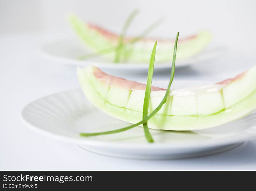 Honey due melons on white plate