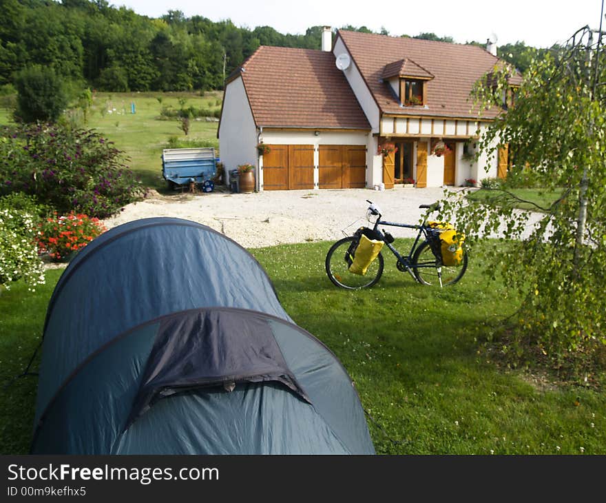 Big green tent in garden. In background bike and house. Big green tent in garden. In background bike and house