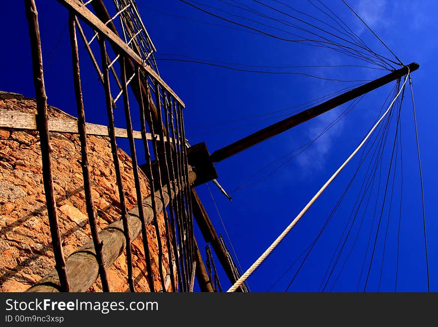 Another view of an old windmill located on a hill in Formentera, Spain staring against a blue summer sky. Another view of an old windmill located on a hill in Formentera, Spain staring against a blue summer sky