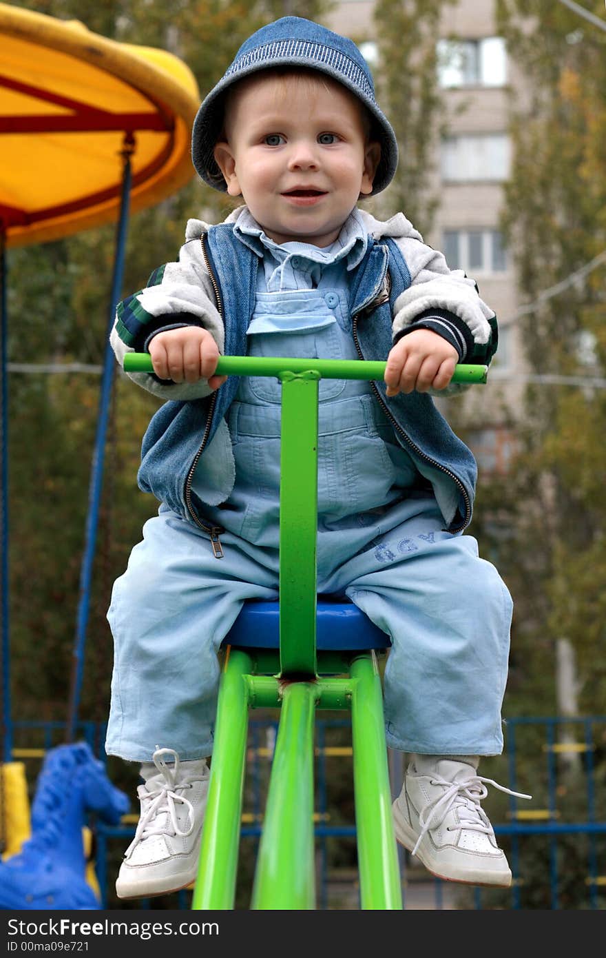 Excited little boy on a swing in a playgroung. Excited little boy on a swing in a playgroung