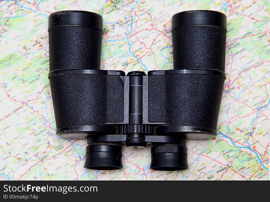 A black binoculars and a map. A black binoculars and a map