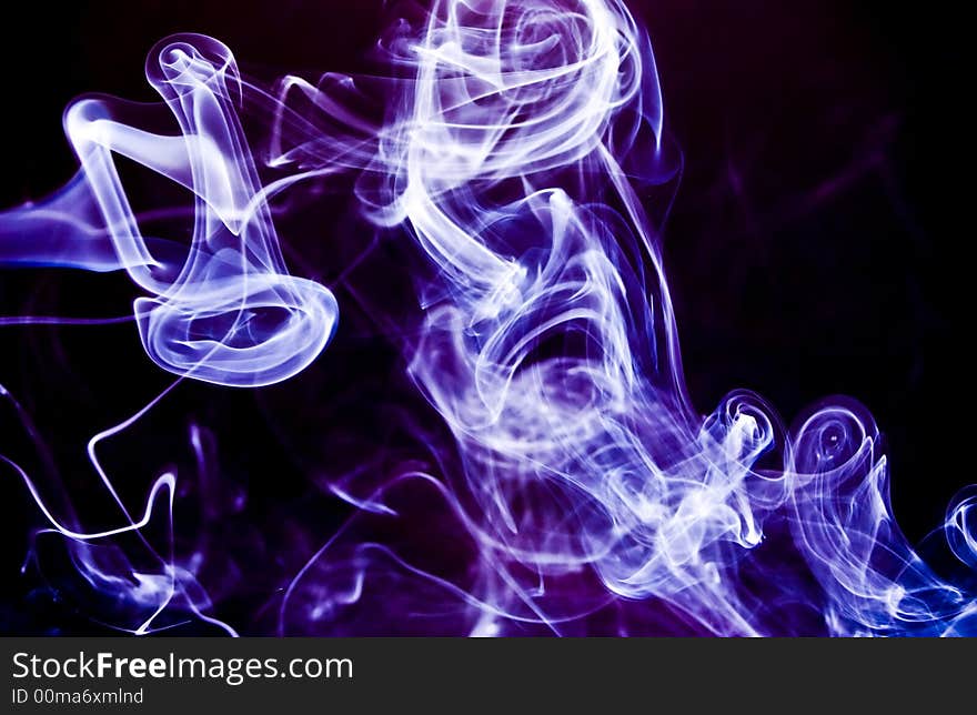 Swirling, twirling plumes of lilac or lavender colored smoke on a black background. Swirling, twirling plumes of lilac or lavender colored smoke on a black background.