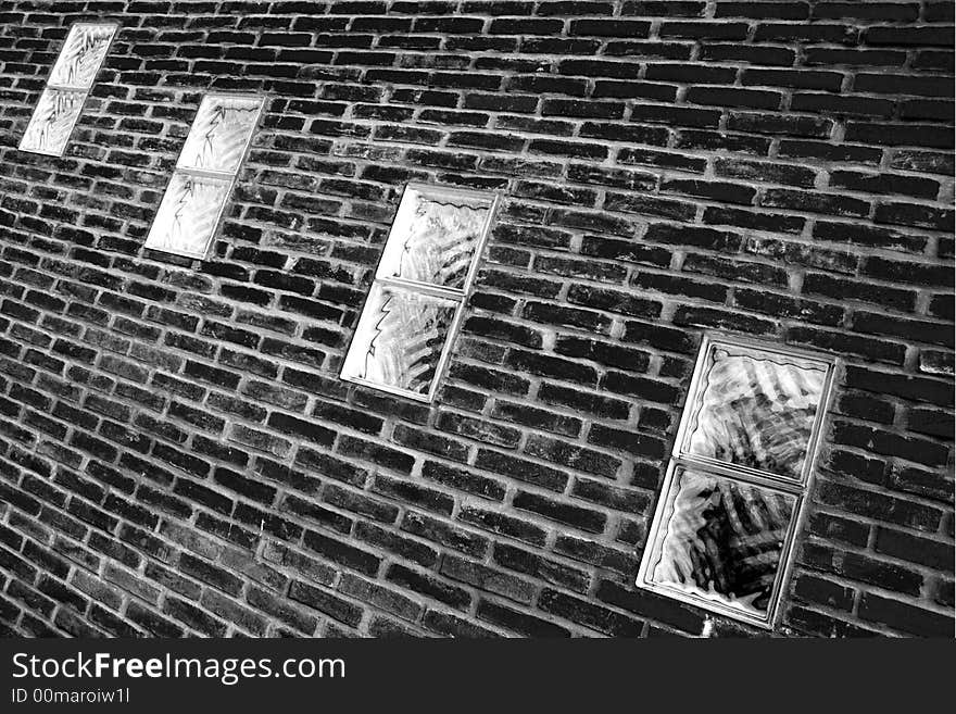 Four windows in a brick wall in black and white