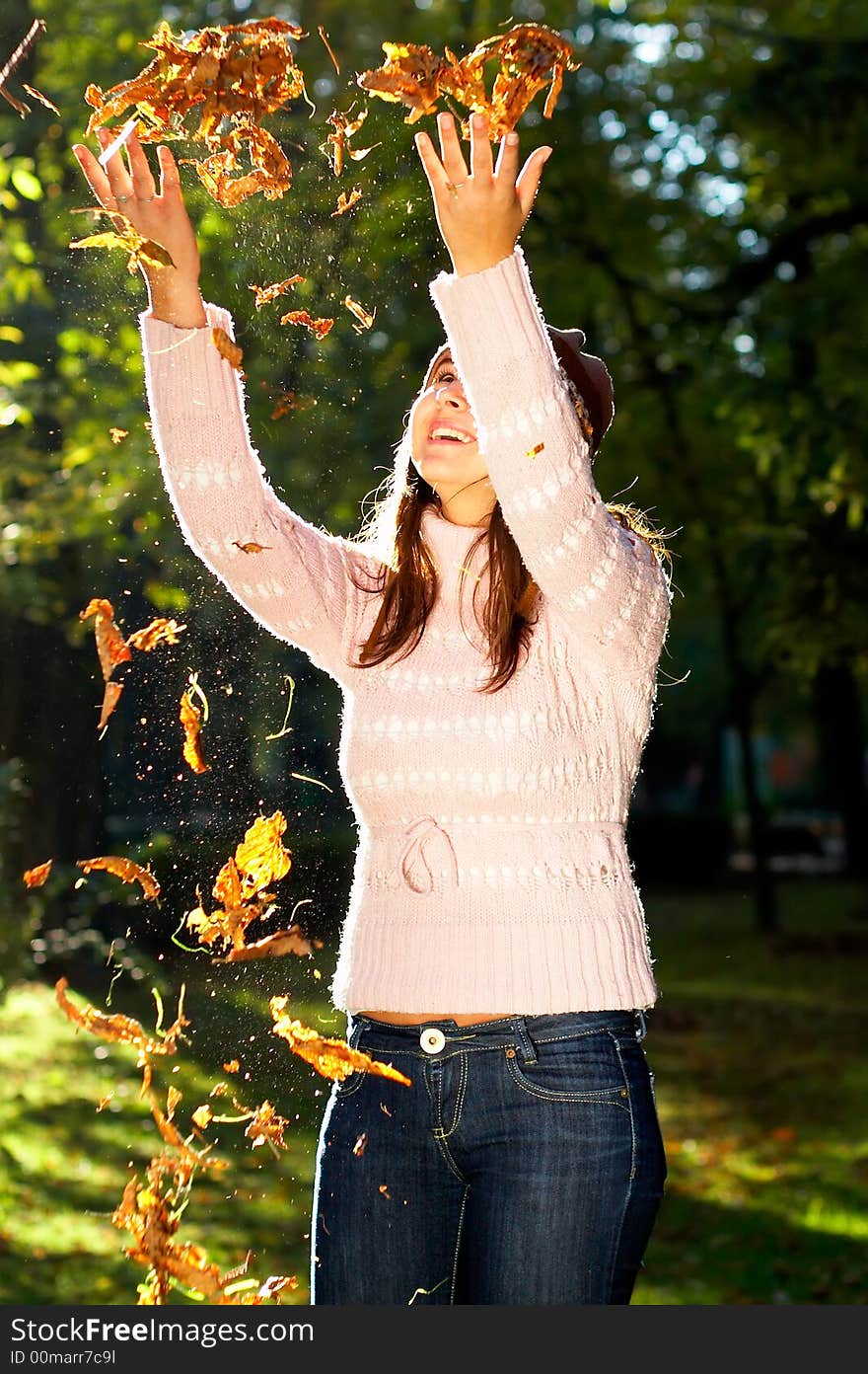 Beautiful young girl throwing golden leaves in the air - great smile. Beautiful young girl throwing golden leaves in the air - great smile