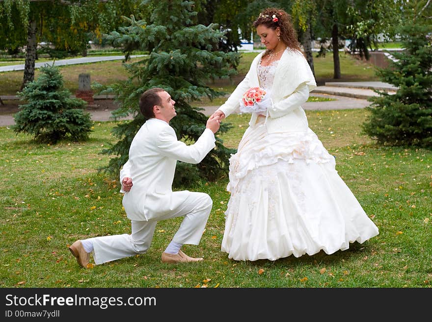 Young couple in wedding wear with bouquet of roses. Young couple in wedding wear with bouquet of roses.