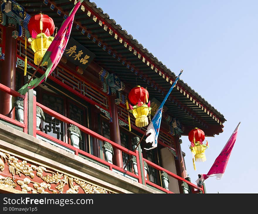 Front of a chinese house with three red and yellow lanterns. Front of a chinese house with three red and yellow lanterns