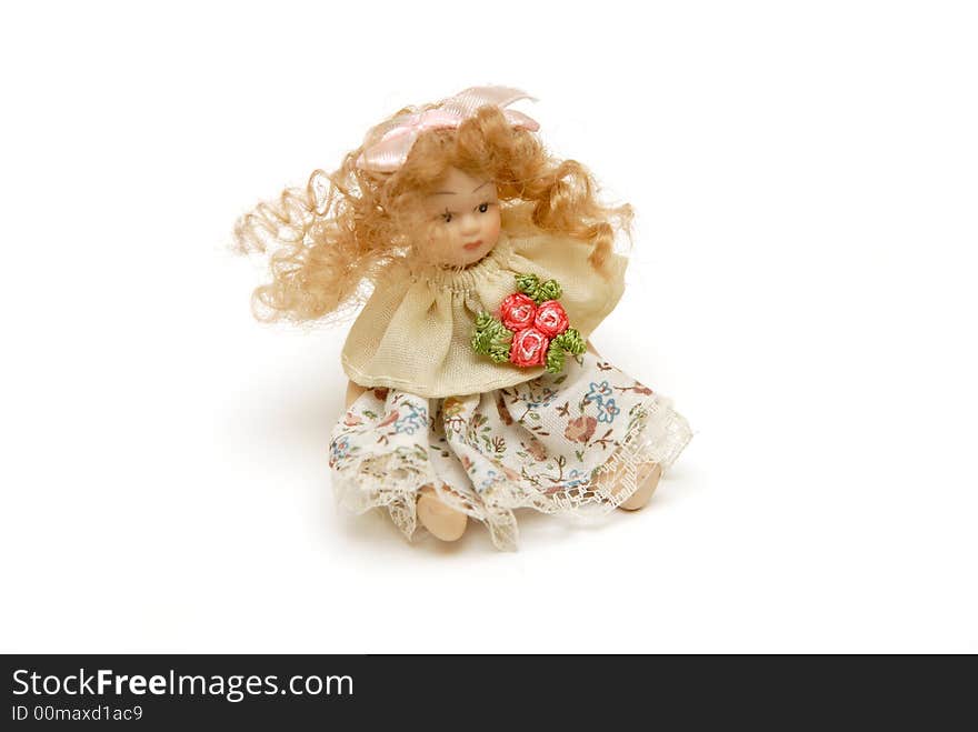 Small sitting ceramic dolly on white background. Small sitting ceramic dolly on white background