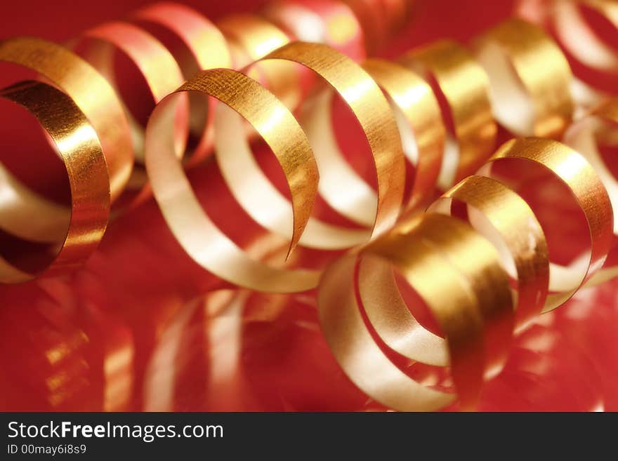 Golden curly ribbons on red background. Golden curly ribbons on red background