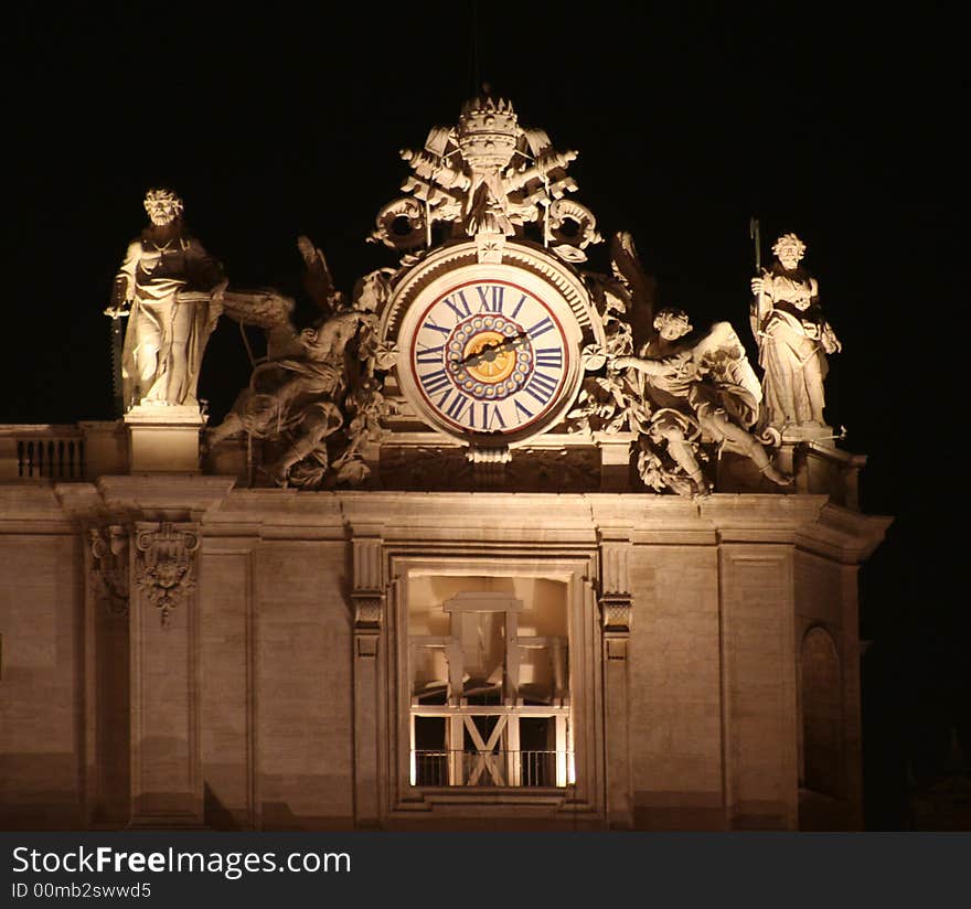 St. Peter's (Rome - Italy - Vatican City) Left side with clock and two sculptures by side at night / Evocative lights on the house of the Pope and Christians. St. Peter's (Rome - Italy - Vatican City) Left side with clock and two sculptures by side at night / Evocative lights on the house of the Pope and Christians