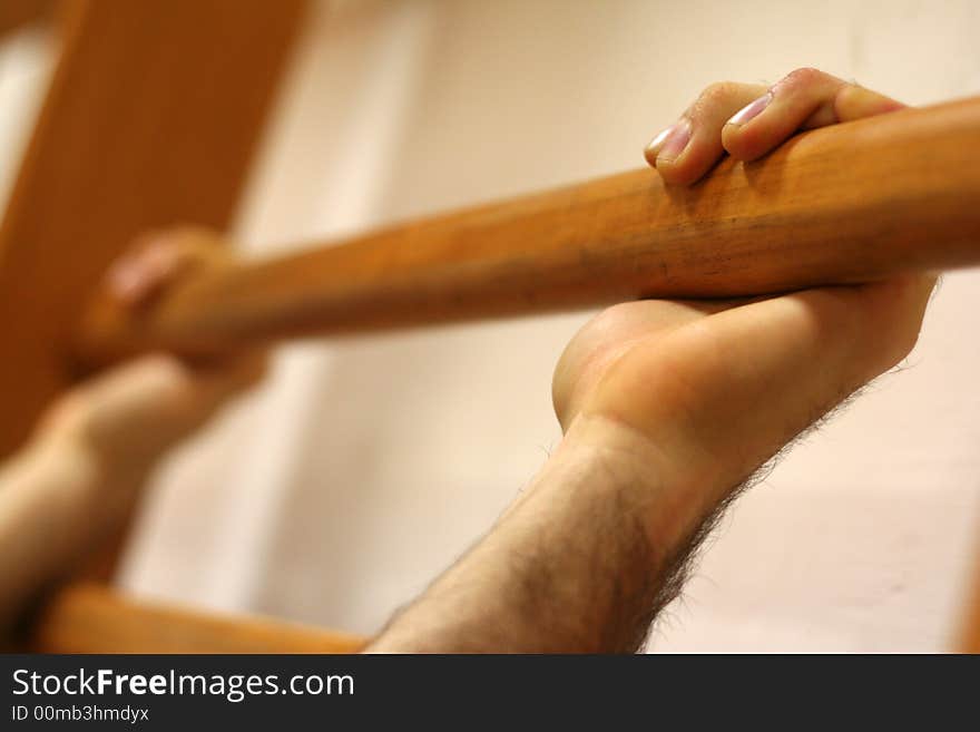 Hands of a man who grasps the shaft of a wall bars. Hands of a man who grasps the shaft of a wall bars