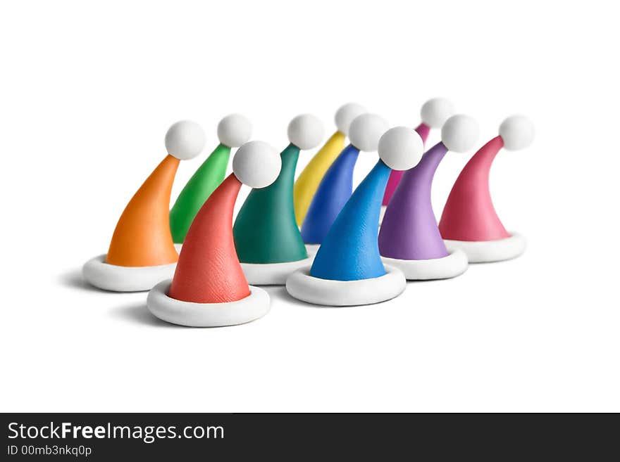 Multicolored plasticine Santa hats on a white background. Multicolored plasticine Santa hats on a white background