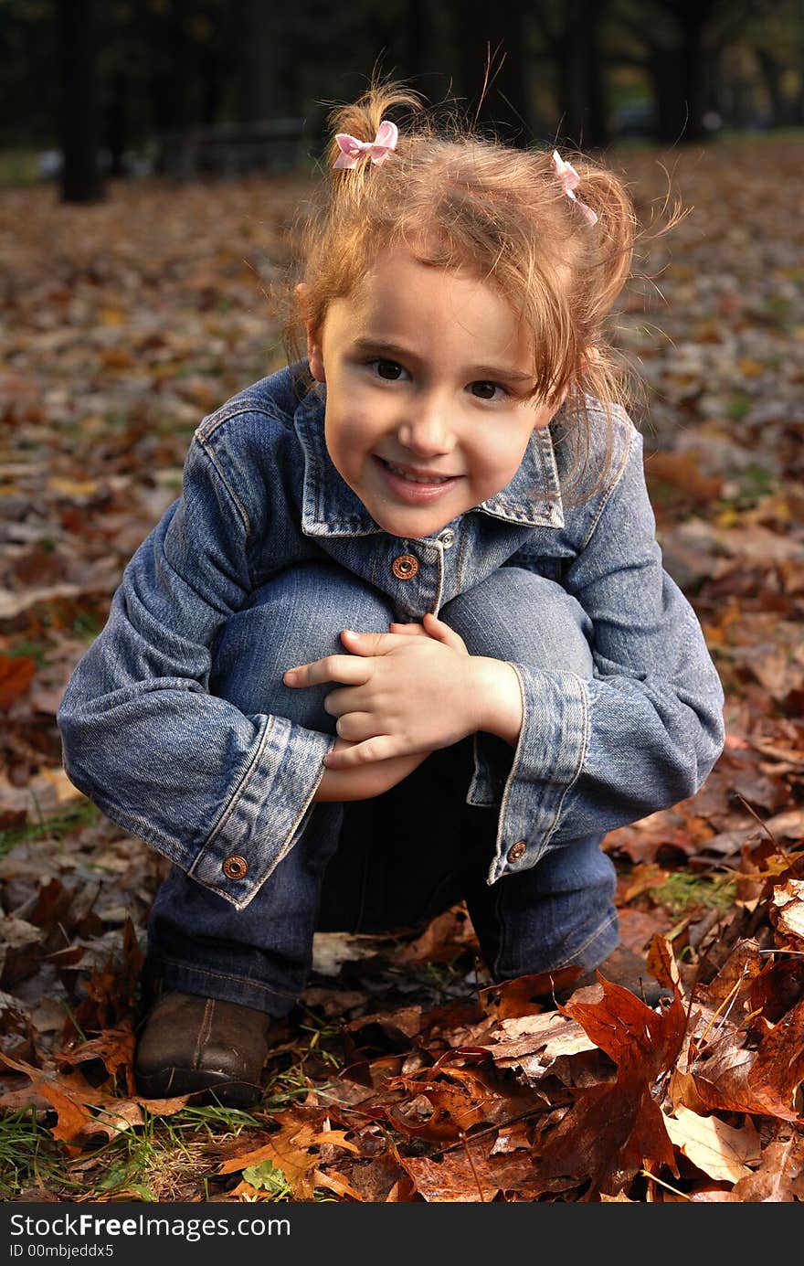 Little girl sitting in fall leaves. Little girl sitting in fall leaves.