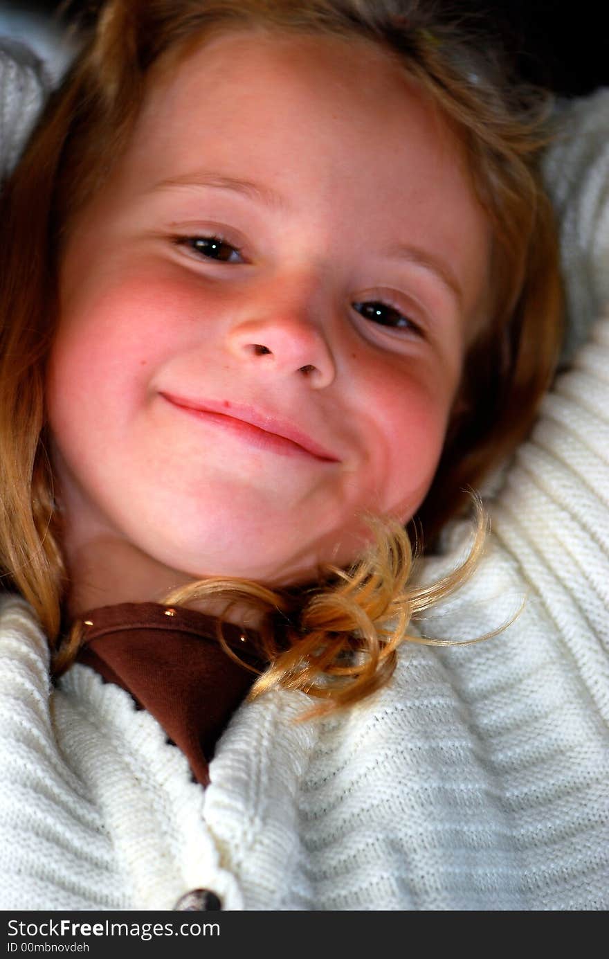 A pretty little girl with a sweet smile poses for an outdoor portrait. A pretty little girl with a sweet smile poses for an outdoor portrait.