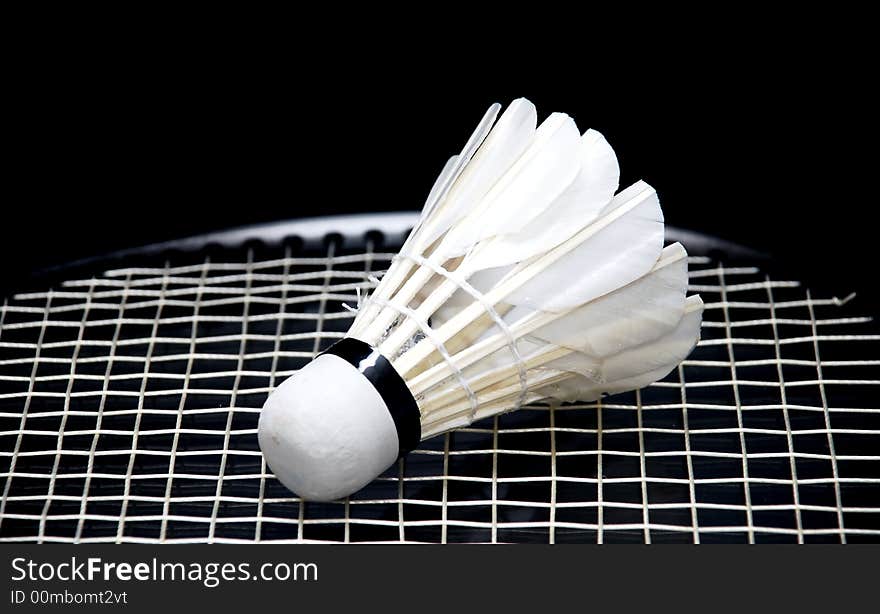 Focus a shuttllecocks image on the badminton racket. Focus a shuttllecocks image on the badminton racket