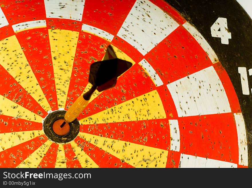 Dartboard with single dart in the middle or bulls -eye.  symbol of hitting the target or making the goal