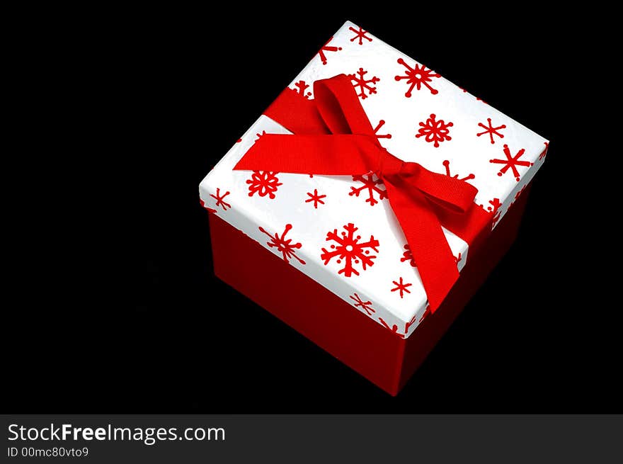 Red and white gift box on black background with copy space