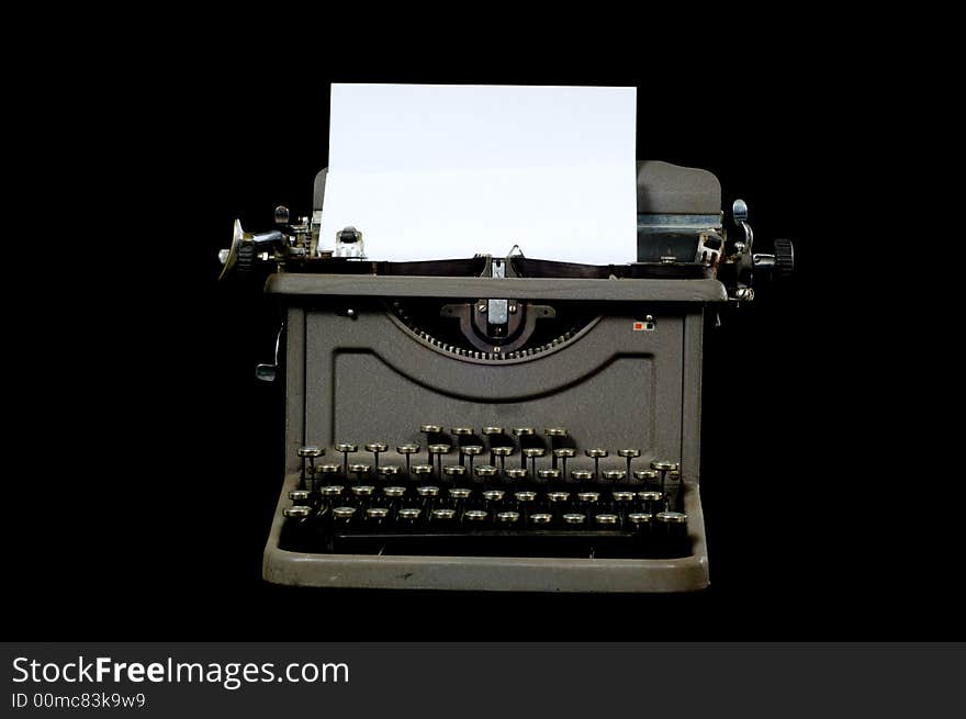 A gray silver vintage typewriter on black background with copy space on the paper in the typewriter carriage