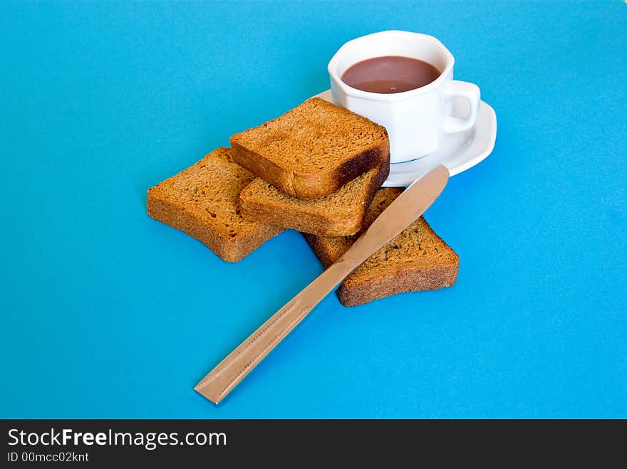 Slices of bread, coffee and coffee cup and knife, arranged on a blue background. Slices of bread, coffee and coffee cup and knife, arranged on a blue background