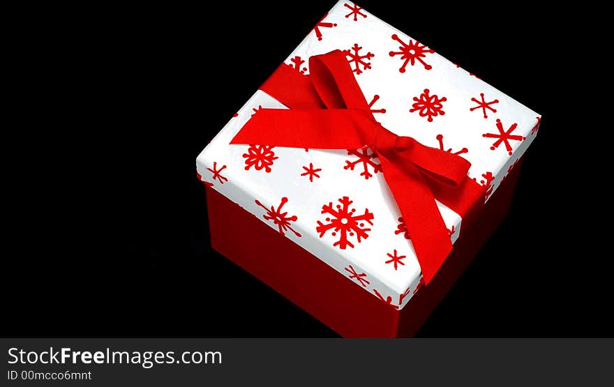 Red and white gift box on black background with copy space