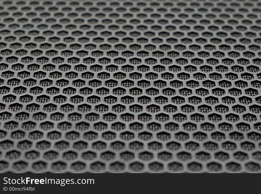 Background of hexagonal pattern of speaker grille. selective focus.