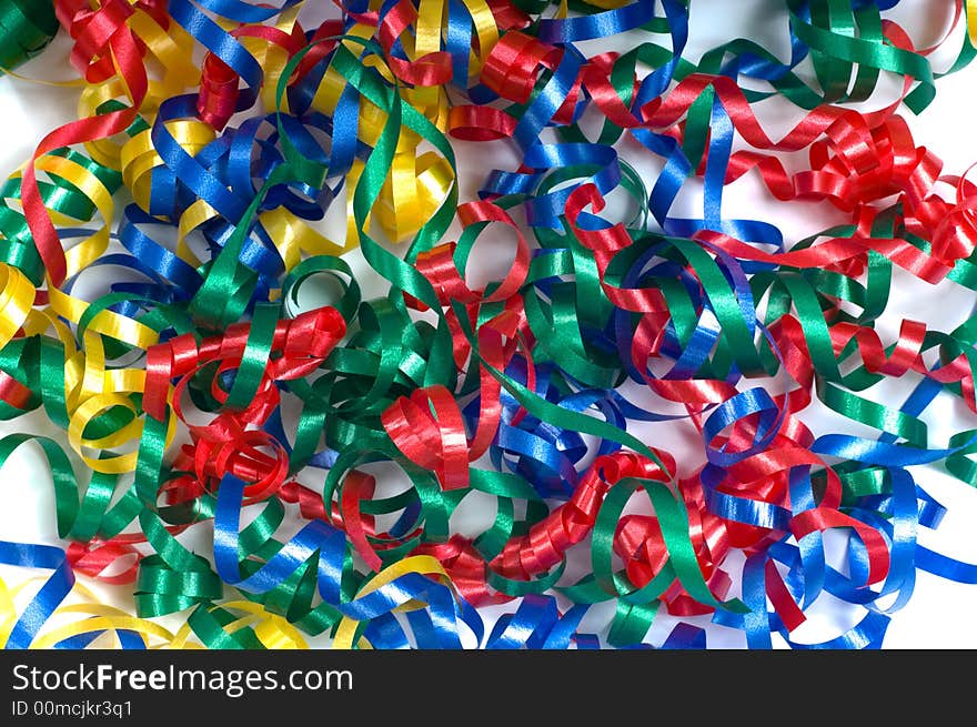 A background consisting of primary colored curly ribbons in a pile on a white background, can be used for an announcement of any kind of celebration, new years, birthday etc. A background consisting of primary colored curly ribbons in a pile on a white background, can be used for an announcement of any kind of celebration, new years, birthday etc.