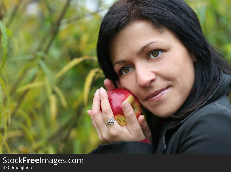 Woman and apple in autumn park